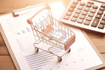 Shopping cart and calculator placed on data report drawings