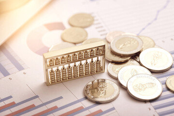Abacus and Coins Placed on Data Sheets - Concepts of Monetary Finance