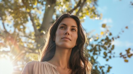 Fototapeta premium A beautiful woman with a radiant smile standing in a sunlit park.