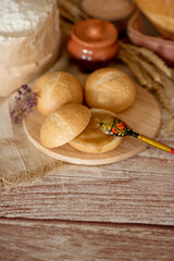 delicious little buns with honey. breakfast with rolls and honey. small delicious buns on the background of flour and wheat ears.