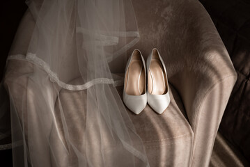 Bride's shoes and veil on a chair	