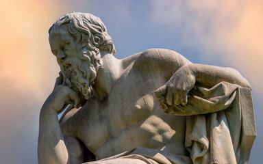 Socrates marble statue, the ancient Greek philosopher, under a fiery sky Travel to Athens, Greece.