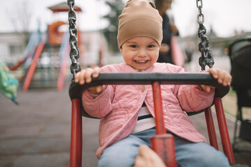 Smiling girl having fun on a swing