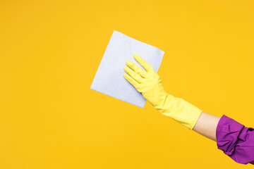 Close up cropped female hold in hand purple dust cloth while do housework tidy up cleaning isolated on plain yellow orange color background studio. Housekeeping concept Copy space advertising mock up