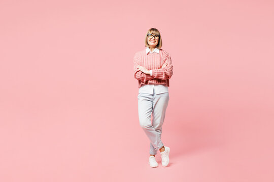 Fototapeta Full body elderly woman 50s years old wear sweater shirt casual clothes glasses hold hands crossed folded look camera isolated on plain pastel light pink background studio portrait. Lifestyle concept.