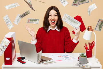 Young surprised fun employee business woman wear red sweater shirt sit work at office desk with pc...