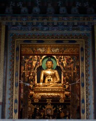 Fototapeta na wymiar Impressive golden statue of Buddha behind the entrance in Kushaknagar, India