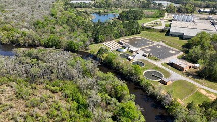 Fototapeta na wymiar Water treatment plant in wooded landscape near peaceful river in Springtime in a small Southern town in America