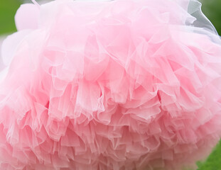 The fabric of the skirt is made of pink tulle