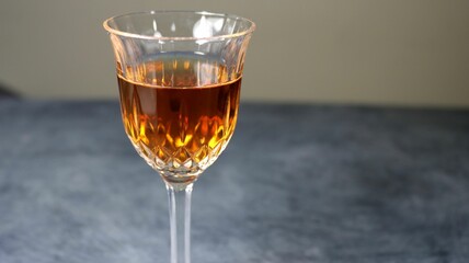Closeup of a glass of brown cocktail on a gray background