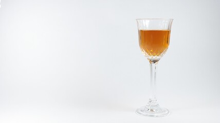 Closeup of a glass of brown cocktail on a white background with copy space
