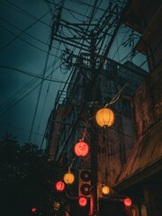 Row of vibrant lanterns hung up in front of an illuminated power line in Okinawa, Japan.