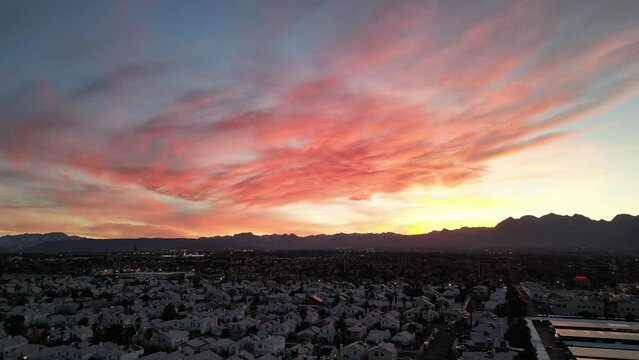 Drone flying through a Summerlin neighborhood with colorful sunset sky on the horizon in Nevada