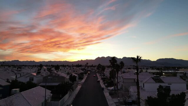 Drone flying through a Summerlin neighborhood with a colorful sunset sky in Nevada
