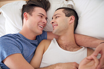 Men, gay and couple or bed relax in apartment resting with lgbt pride with comfortable love, happiness or connection. Male person, queer and smile with bonding support in home together, calm or peace