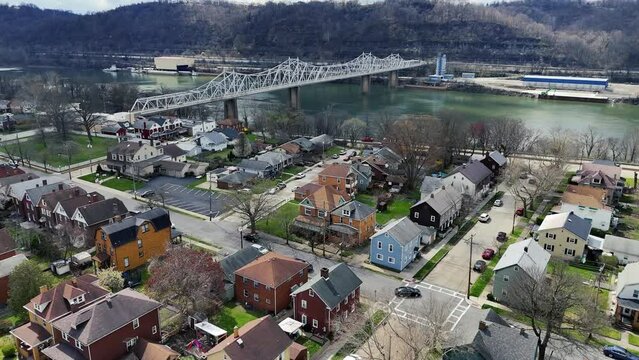 A daytime aerial establishing shot of Ambridge, Pennsylvania -- a small river town north of Pittsburgh. The Ambridge Bridge in the distance over the Ohio River.  	