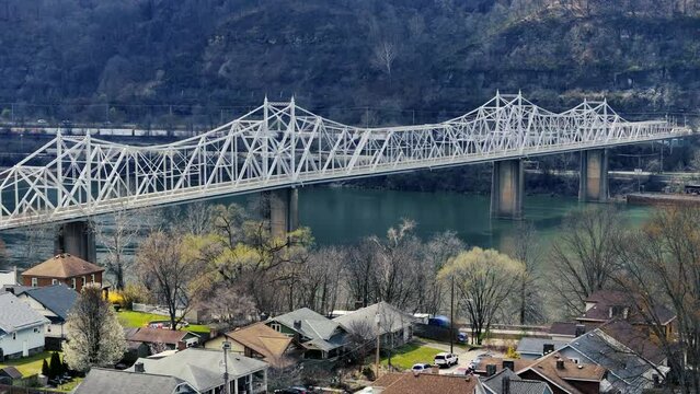 A slowly rising aerial establishing shot of the Ambridge Bridge over the Ohio River in late winter. Pittsburgh suburbs.
