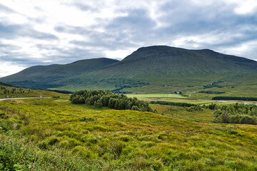 Epic dramatic landscape image of Three Sisters in Glencoe in Scottish Highlands on a wet Summer...