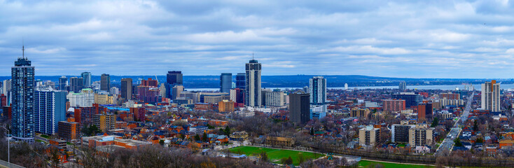 Hamilton Ontario city skyline, downtown buildings, horizon, and the Lake Ontario in the distance in...