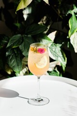 Crystal-clear glass of Italian peach soda on the white table on a sunny day