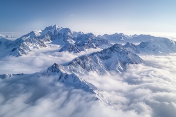 High-altitude view of jagged peaks of a snowcapped mountain range from an airplane above a sea of...