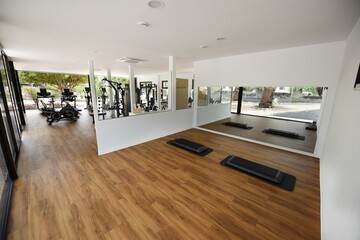 Spacious gym with a wide selection of exercise equipment in the glass building