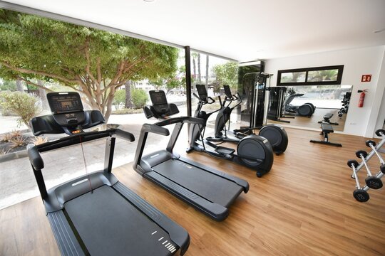 Spacious gym with a wide selection of exercise equipment in the glass building