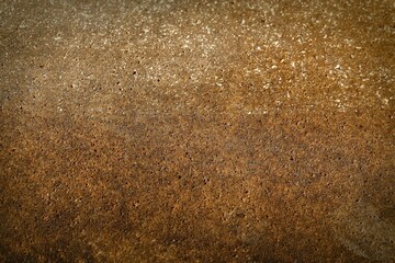 Close-up shot of a rusty brown-orange concrete stone wall texture
