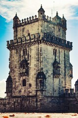 Fototapeta na wymiar a tall building with many turrets and a tower clock on top