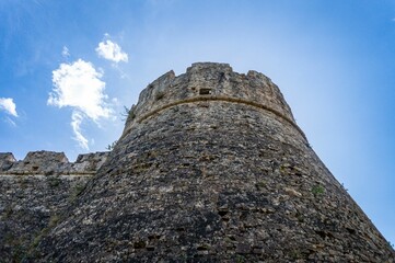 castle wall and the sky, seen from below, against the blue sky © Wirestock