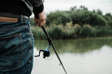 a man with a fishing rod in his hand is looking back at the water
