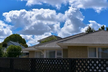 Stunning sky with fluffy white clouds over a residential house