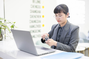 Sick office worker taking pills