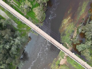 Aerial view of a Pedestrian footbridge over tanin coloured Avon River, Toodyay, Western Australia
