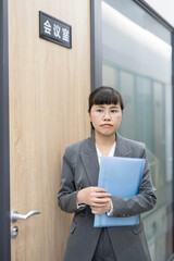 White-collar workers standing outside the conference room door