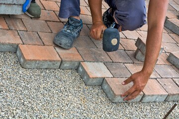 Construction worker repairing a brick wall in an outdoor area