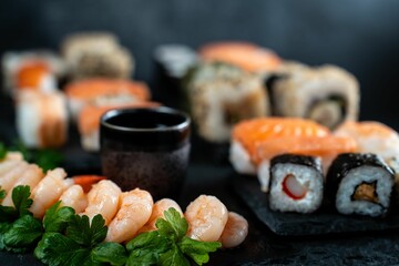 Flat lay shot of a table with an abundant selection of sushi rolls and dipping sauces