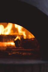 a pizza oven with flames in the background, seen from a distance