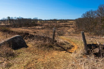 Two old, wooden gate fence posts on a field in the Gettysburg National Military Park on a sunny winter day - obrazy, fototapety, plakaty