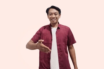 Happy Friendly young handsome Asian man wearing casual clothes outstretched hand for greeting. People lifestyle concept - obrazy, fototapety, plakaty