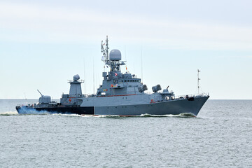 Fototapeta na wymiar Russian warship armed with armament sails into sea toward military target to attack and destroy enemy, military ship performing strategic maneuver, Russian sea power deployment for tactical advantage