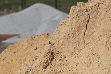 Baumaterial, Sand- und Kieshaufen auf einer Baustelle