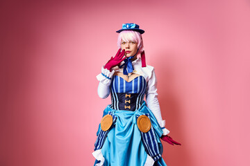 shocked pretty woman with blue hat and red gloves cosplaying anime character and looking at camera