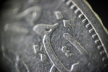texture of engraved hieroglyphs in Arabic on a coin in macro	
