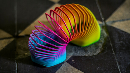 A multi-colored spring stands on the tiles in the corridor	
