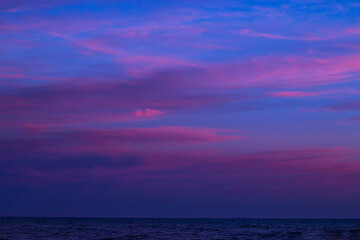 Beautiful clouds in a colorful sky at sunset in summer over the sea