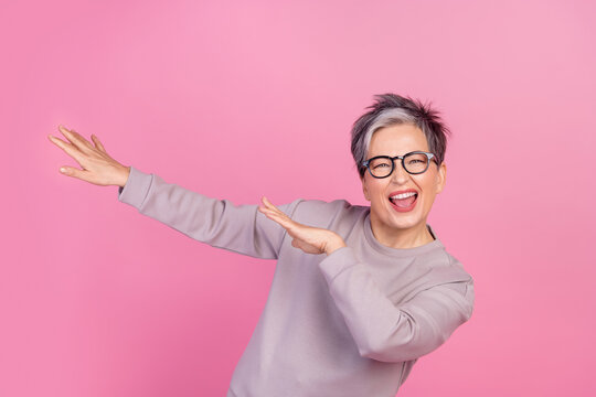 Photo of cheerful glad good mood woman pensioner celebrating victory winning dancing isolated on pink color background