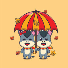 Cute couple donkey with umbrella at autumn season. 