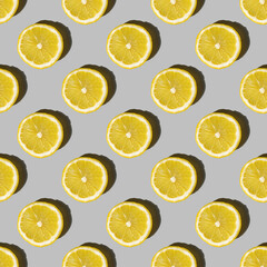 Uniform pattern of lemon slices with shadow on a gray background. Flat layout