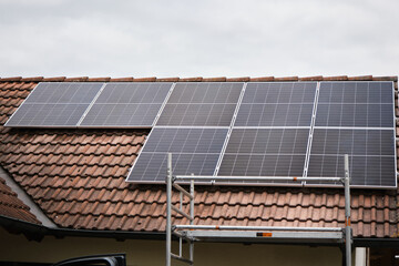 Solar panels on the roof of a house with red tiles